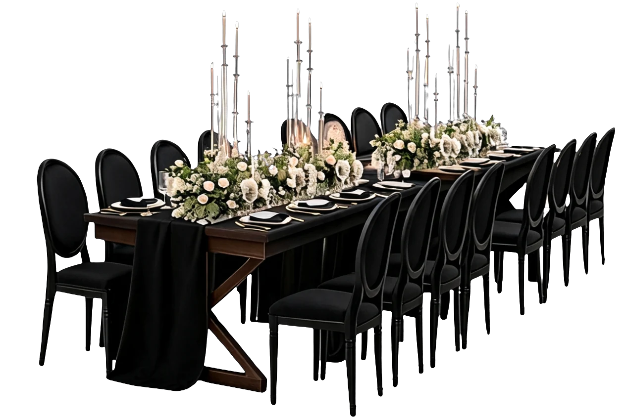 A long black dinner table lined with chairs, white roses and tall candles